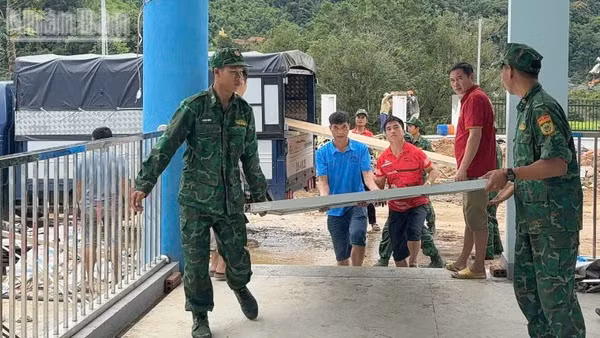 Cán bộ, chiến sĩ Đồn Biên phòng Mường Lèo giúp Trường phổ thông nội trú tiểu học và trung học cơ sở Mường Lèo chuẩn bị khánh thành và đón năm học mới. (Ảnh: QUÀNG HÙNG)