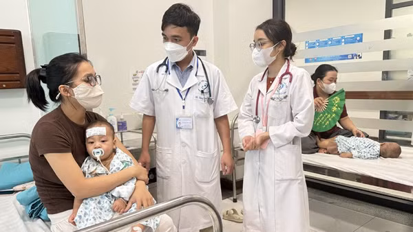 Các y, bác sĩ Bệnh viện Nhi Hà Nội chăm sóc trẻ bị bệnh tay chân miệng trên địa bàn Hà Nội. (Ảnh: VÂN VÂN) 