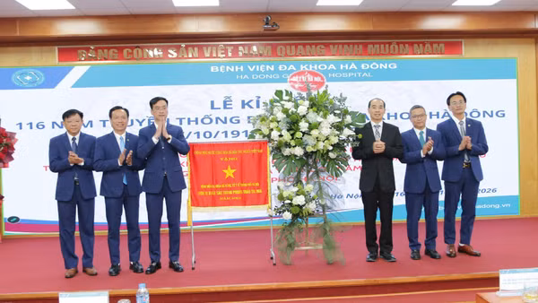 Thừa ủy quyền của Thủ tướng Chính phủ, Tiến sĩ, bác sĩ Nguyễn Đình Hưng, Phó Giám đốc Sở Y tế Hà Nội trao Cờ thi đua của Chính phủ cho lãnh đạo Bệnh viện đa khoa Hà Đông tại Lễ kỷ niệm. (Ảnh: VĂN LẬP)
