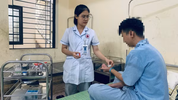 Các y, bác sĩ cấp thuốc và hướng dẫn người bệnh đang điều trị tại Bệnh viện Tâm thần Mỹ Đức uống thuốc đúng giờ. (Ảnh: HUY SƠN)