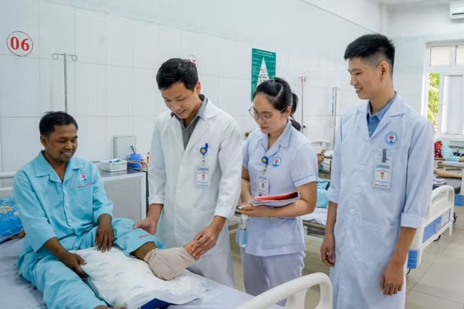Bác sĩ Bệnh viện đa khoa tỉnh Quảng Trị kiểm tra vết thương bàn chân của bệnh nhân sau phẫu thuật. (Ảnh: Bệnh viện đa khoa tỉnh Quảng Trị)