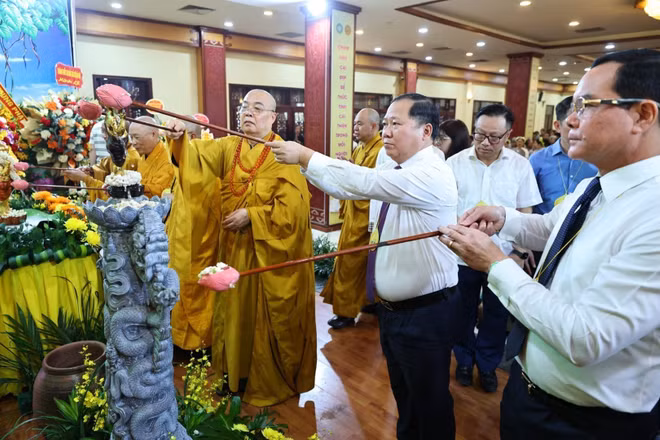 Các đại biểu và Phật tử thực hiện nghi thức tắm Phật. (Ảnh: Minh Đức/TTXVN)