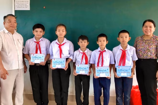Đại diện Hội Hỗ trợ gia đình liệt sĩ trao quà cho học sinh khó khăn.