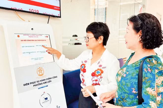 Hướng dẫn người dân lấy số thứ tự để thực hiện thủ tục hành chính tại Điểm tiếp nhận, phục vụ hành chính công phường Kim Liên (Hà Nội). (Ảnh: NGUYÊN BẢO)