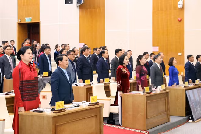 Đại biểu dự kỳ họp thực hiện nghi thức chào cờ.