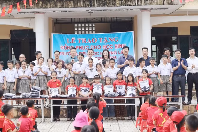 Đại diện Văn phòng Báo Nhân Dân tại Hà Tĩnh cùng lãnh đạo cấp uỷ, chính quyền địa phương và nhà tài trợ trao tặng gần 500 áo đồng phục cho học sinh Trường tiểu học Hương Liên.