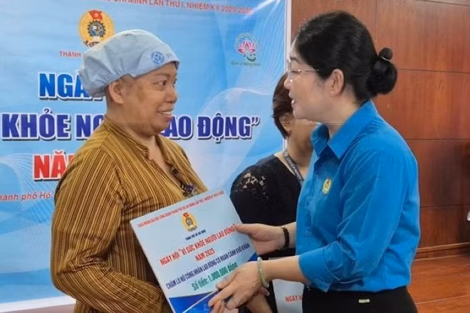 Bà Nguyễn Kim Loan, Phó Chủ tịch Liên đoàn Lao động Thành phố Hồ Chí Minh tặng quà cho lao động nữ bị bệnh hiểm nghèo. (Ảnh: Mai Chi) 
