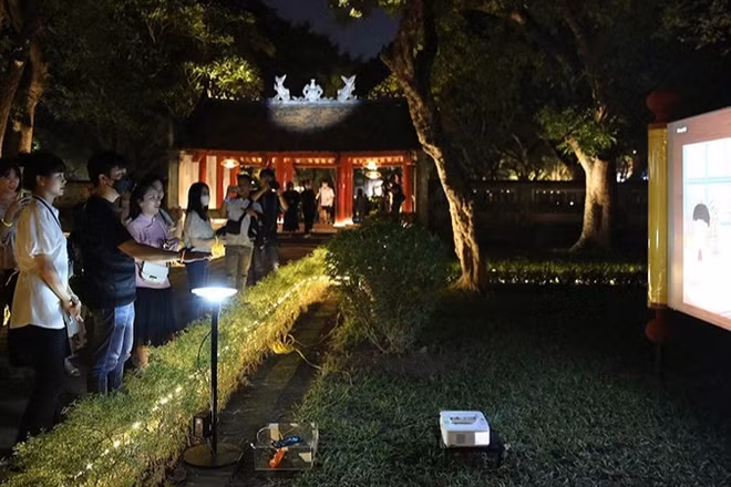 Du khách tham quan tour “Trải nghiệm đêm Văn Miếu-Quốc Tử Giám”. (Ảnh Thành Nguyễn)