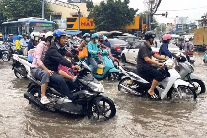 Nước dâng sớm, rút chậm trên đường Phạm Hữu Lầu, kéo dài từ cầu Phước Long đến đường Huỳnh Tấn Phát (Thành phố Hồ Chí Minh) khiến các phương tiện di chuyển chậm, khó khăn. (Ảnh: Hương Giang/TTXVN)