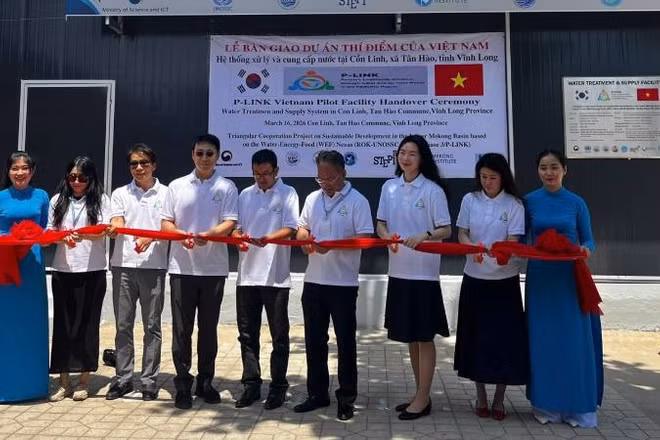 Đại biểu thực hiện nghi thức cắt băng khánh thành hệ thống lọc nước RO tại xã Tân Hào (tỉnh Vĩnh Long).