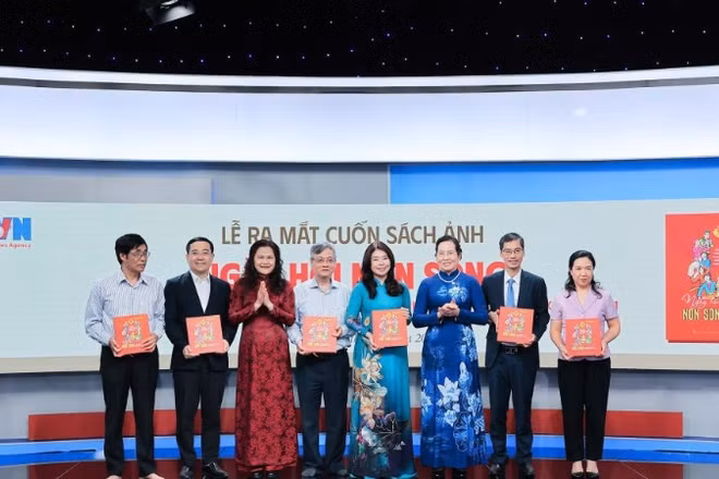 Phó Tổng Giám đốc Thông tấn xã Việt Nam Nguyễn Thị Sự tặng sách ảnh "Ngày hội non sông" cho các đại biểu.