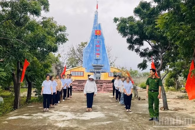 Thanh thiếu niên có hành vi vi phạm tập trung tại khuôn viên Đài tưởng niệm Liệt sĩ xã Phước Dinh để nghe Công an xã tuyên truyền, giáo dục pháp luật và tham gia lao động công ích có sự giám sát của công an xã. (Ảnh: NGUYỄN TRUNG)