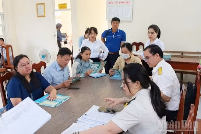 Cán bộ thuế tỉnh Khánh Hòa tuyên truyền, hướng dẫn các hộ kinh doanh tìm hiểu những quy định về quyền lợi, nghĩa vụ theo Nghị định 141/2026/NĐ-CP vừa được Chính phủ ban hành ngày 29/4/2026. (Ảnh: đơn vị cung cấp)