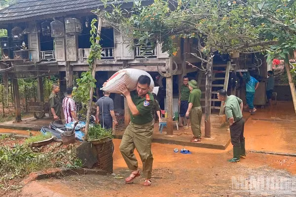 Công an xã Bao La giúp người dân trong xã khắc phục hậu quả mưa lũ.