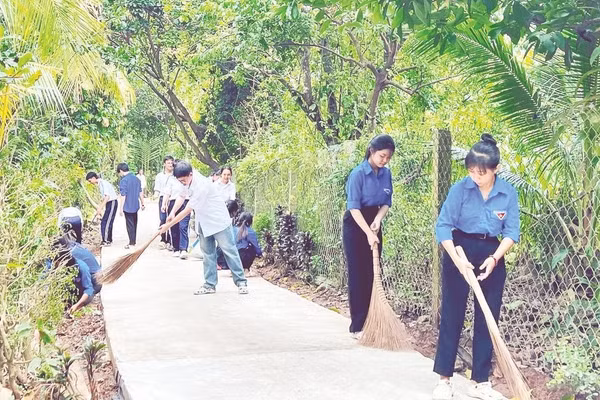 Đoàn viên, thanh niên và học sinh xã Phú Túc dọn vệ sinh tuyến đường nông thôn.