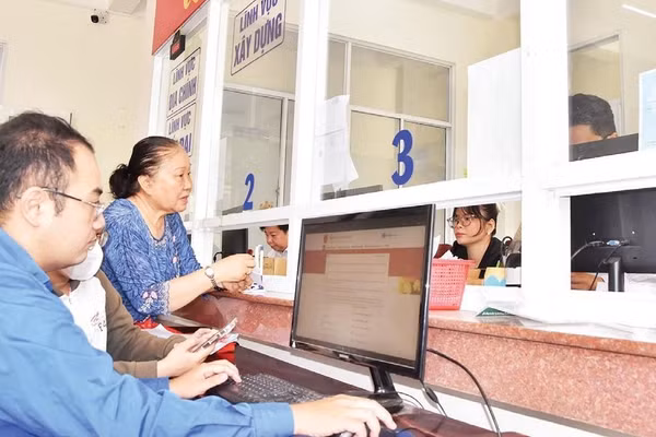 Cán bộ Trung tâm Phục vụ hành chính công phường Đạo Thạnh (tỉnh Đồng Tháp) hỗ trợ người dân xử lý hồ sơ trên môi trường số.