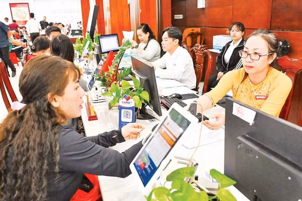 Người dân làm thủ tục hành chính tại xã Tân Nhựt (Ảnh THẾ ANH).