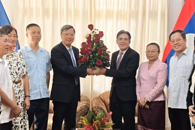 Đại sứ Lê Quang Long tặng hoa chúc mừng Đại sứ Vanhtha Sengmeuang và toàn thể cán bộ nhân viên Đại sứ quán Lào. (Ảnh: Đại sứ quán Việt Nam tại Cuba)