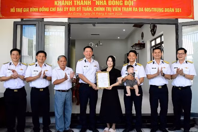 Đại tá Hoàng Quốc Hoàn, Phó Chính ủy Vùng 5 Hải quân trao quyết định hỗ trợ kinh phí xây dựng nhà đồng đội cho gia đình Đại úy Bùi Sỹ Tuấn. (Ảnh do Vùng 5 Hải quân cung cấp) 