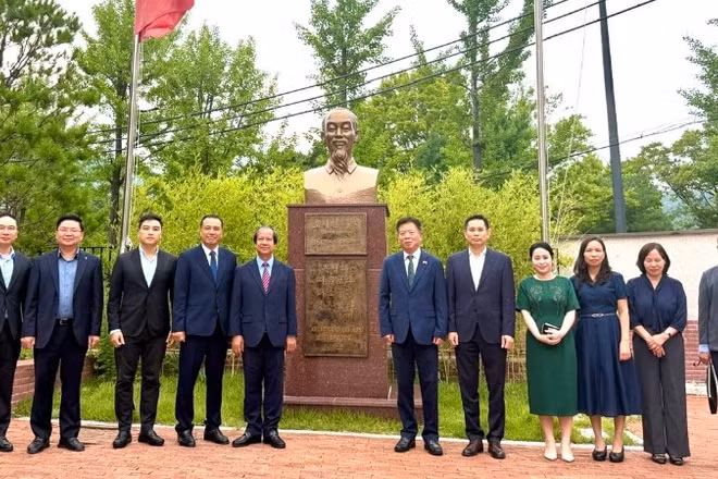 Đoàn công tác chụp ảnh cùng Đại sứ Vũ Hồ và cán bộ Đại sứ quán bên Tượng đài Chủ tịch Hồ Chí Minh trong khuôn viên Đại sứ quán. 