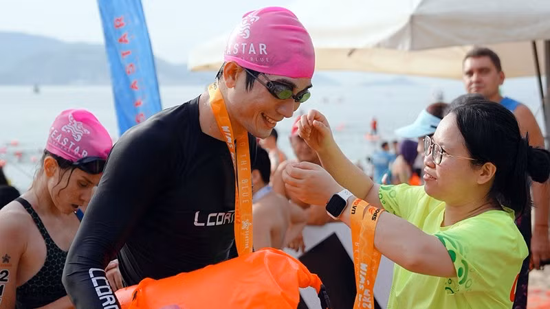 Vận động viên khiếm thị Huỳnh Ngọc Tiến nhận huy chương tại một giải đấu open water (bơi trong môi trường tự nhiên). (Ảnh: Nhân vật cung cấp)