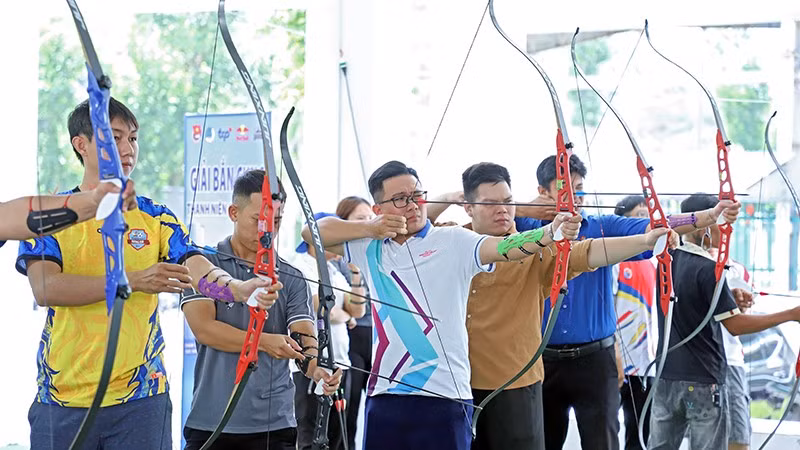 Thanh niên công nhân tranh tài bắn cung tại ngày hội.