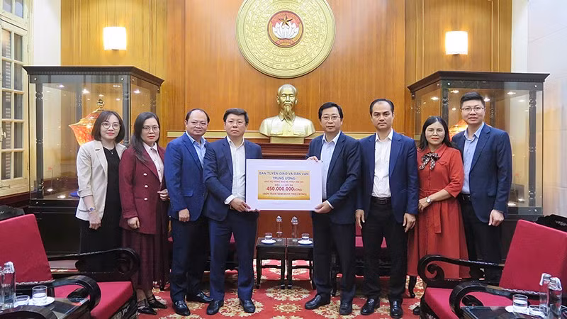 Đại diện lãnh đạo, cán bộ Ban Tuyên giáo và Dân vận Trung ương trao biển tượng trưng số tiền ủng hộ đồng bào vùng lũ tại trụ sở Ủy ban Trung ương Mặt trận Tổ quốc Việt Nam.