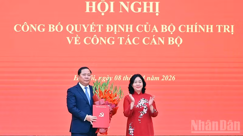 Đồng chí Bùi Thị Minh Hoài (bên phải) trao Quyết định của Bộ Chính trị, tặng hoa chúc mừng đồng chí Nguyễn Phi Long.