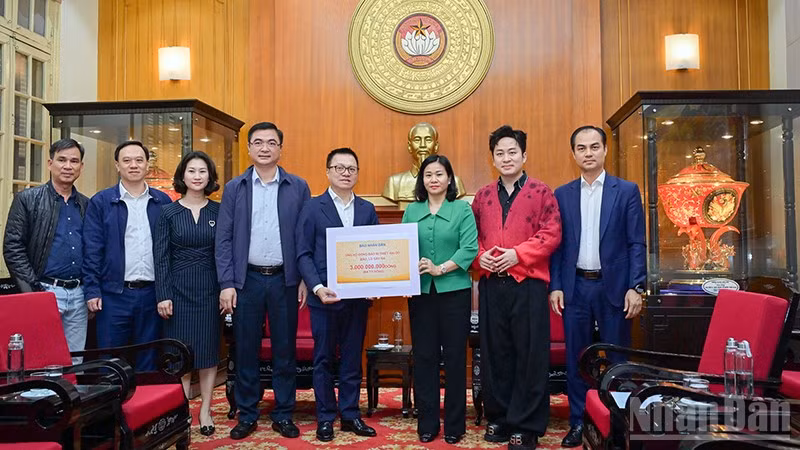Tổng Biên tập Báo Nhân Dân Lê Quốc Minh trao kinh phí ủng hộ đồng bào khắc phục hậu quả bão, lũ. (Ảnh: BẢO LONG)