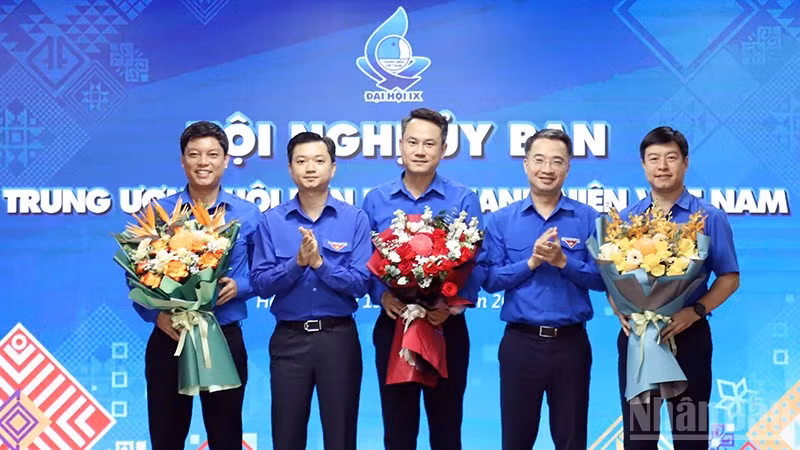 Đồng chí Nguyễn Kim Quy, Bí thư Trung ương Đoàn, Chủ tịch Hội Liên hiệp Thanh niên Việt Nam (ở giữa) nhận hoa chúc mừng từ Ban Bí thư Trung ương Đoàn tại Hội nghị. (Ảnh: LÂM HẢI)