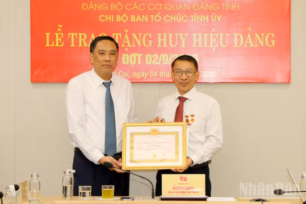 Phó Bí thư Thường trực Tỉnh ủy, Chủ tịch Hội đồng nhân dân tỉnh Lào Cai Hoàng Giang trao Huy hiệu 35 năm tuổi Đảng cho đồng chí Ngô Hữu Quý. (Ảnh: TÂM THỜI)