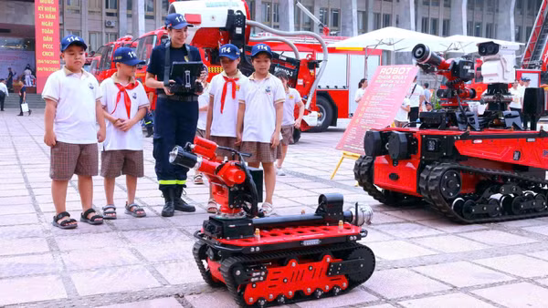Chiến sĩ phòng cháy, chữa cháy và cứu nạn, cứu hộ biểu diễn sử dụng robot chữa cháy cho các em học sinh. (Ảnh: Công an Hà Nội)