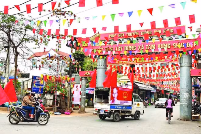Các ngõ, xóm tại xã Tam Hưng đều được trang hoàng cờ hoa tưng bừng, khí thế. (Ảnh ÁNH NGỌC)