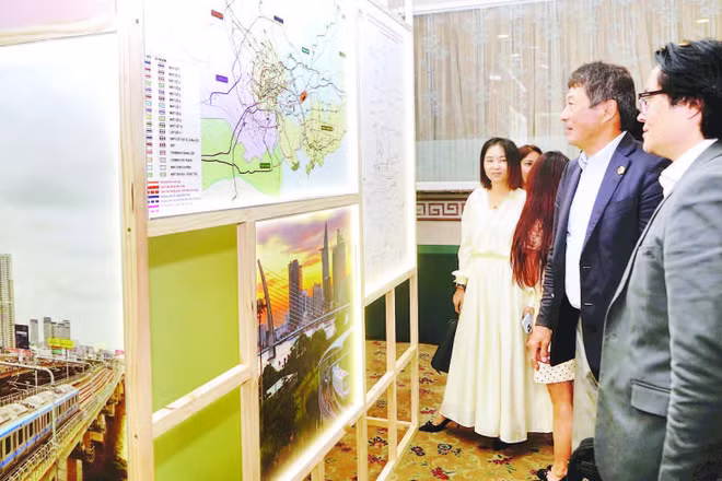 Nhà đầu tư nước ngoài tìm hiểu thông tin về các dự án kêu gọi đầu tư tại buổi gặp gỡ. (Ảnh THẾ ANH)