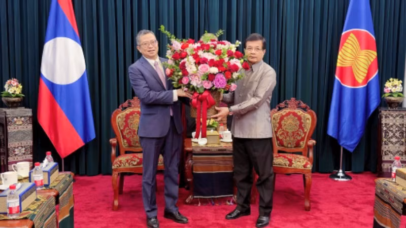 Đại sứ Phạm Thanh Bình tặng hoa chúc mừng Đại sứ Lào tại Trung Quốc Somphone Sichaleun. (Ảnh do Đại sứ quán cung cấp)