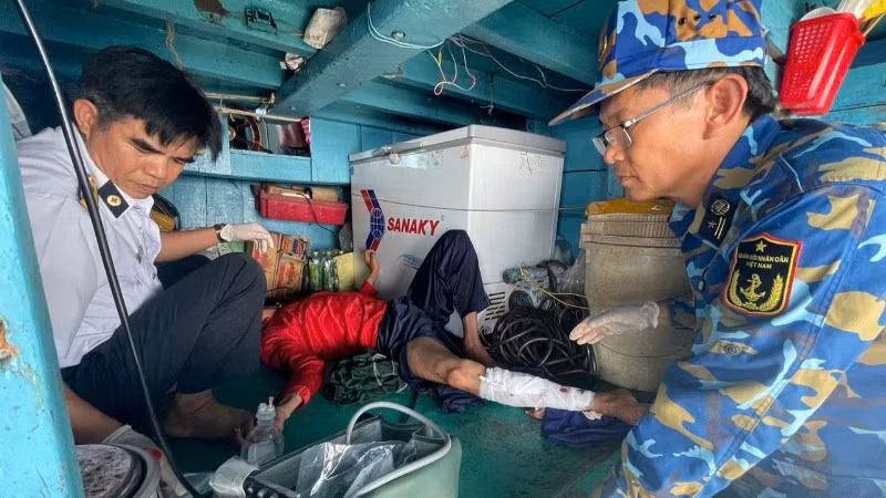 Quân y nhà giàn tiếp cận và vệ sinh, băng bó chân gãy cho nạn nhân.