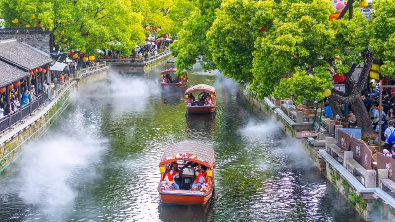 Du khách dạo chơi tại một điểm du lịch ở thành phố Vô Tích, tỉnh Giang Tô, Trung Quốc. (Ảnh: Tân Hoa xã)
