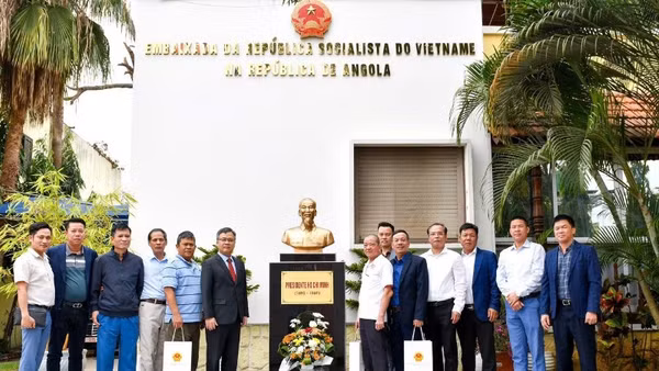 Đại sứ Dương Chính Chức cùng các cựu chiến binh chụp ảnh kỷ niệm bên Tượng đài Bác Hồ trong khuôn viên Đại sứ quán. (Ảnh: Đại sứ quán Việt Nam tại Angola cung cấp)