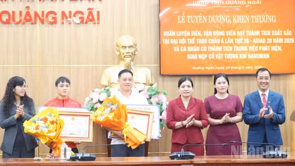 Phó Chủ tịch Thường trực Ủy ban nhân dân tỉnh Quảng Ngãi Y Ngọc cùng lãnh đạo Sở Văn hóa, Thể thao và Du lịch tỉnh Quảng Ngãi trao Bằng khen và tặng hoa chúc mừng vận động viên Đinh Văn Tâm và huấn luyện viên Phạm Quốc Anh. (Ảnh: HIỂN CỪ)