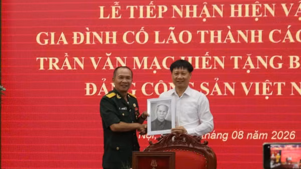 Ông Trần Anh Tuấn (bên trái), đại diện gia đình Đồng chí Trần Văn Mạc ký kết trao tặng kỷ vật cho Bảo tàng Đảng Cộng sản. (Ảnh: HẠNH NGUYỄN)