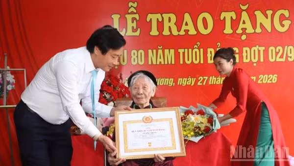 Phó Bí thư Tỉnh ủy Phú Thọ Nguyễn Mạnh Sơn gắn Huy hiệu 80 năm tuổi Đảng cho đảng viên Vương Thị Sỹ, Đảng bộ xã Hoàng Cương. (Ảnh: Ngọc Long)