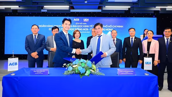 Lãnh đạo ACB và UEH trao biên bản ký kết thỏa thuận hợp tác triển khai Chương trình học bổng ACB-Trần Mộng Hùng. (Ảnh: ACB)