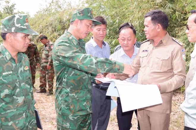 Lực lượng chức năng hai bên trao đổi thông tin trên bản đồ.