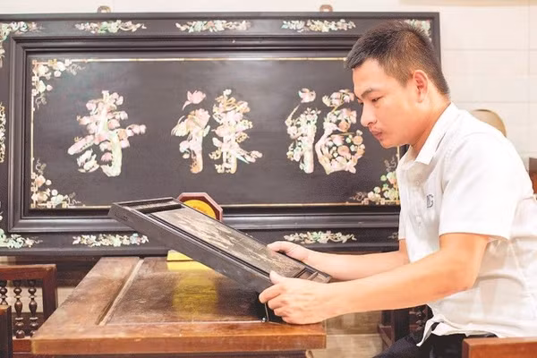 Nghệ nhân trẻ Phan Tấn Đạt bên một sản phẩm khảm ốc.