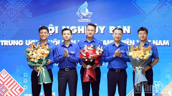 Đồng chí Nguyễn Kim Quy, Bí thư Trung ương Đoàn, Chủ tịch Hội Liên hiệp Thanh niên Việt Nam (ở giữa) nhận hoa chúc mừng từ Ban Bí thư Trung ương Đoàn tại Hội nghị. (Ảnh: LÂM HẢI)