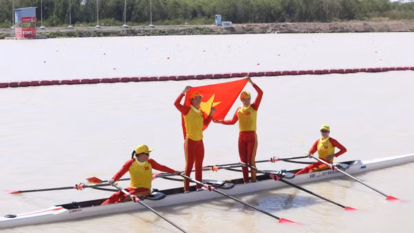 Các tay chèo Việt Nam tự hào giương cao quốc kỳ sau khi cán đích về nhất. 