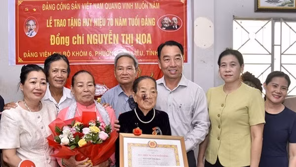 Đồng chí Lữ Quang Ngời (thứ ba, từ phải sang), Phó Bí thư Tỉnh uỷ, Chủ tịch Ủy ban nhân dân tỉnh Cà Mau và đồng chí Tô Việt Thu, Ủy viên Ban Thường vụ Tỉnh uỷ, Bí thư Đảng ủy phường Bạc Liêu (thứ hai từ phải sang) chụp ảnh lưu niệm cùng đảng viên lão thành Nguyễn Thị Hoa và gia đình.