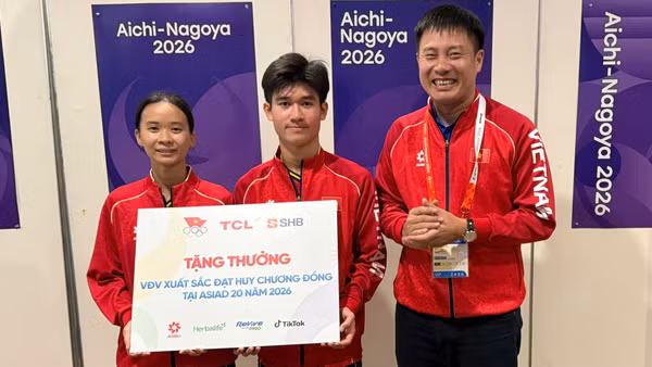 Bộ đôi Nguyễn Hoàng Minh Tân-Trịnh Gia Nghi nhận thưởng sau khi đạt Huy chương Đồng Asian Games. (Ảnh: Bùi Lượng)