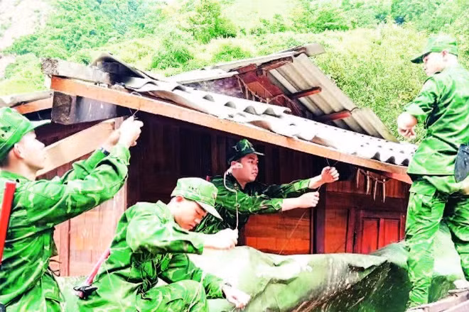 Chiến sĩ Ban Chỉ huy Bộ đội Biên phòng tỉnh Điện Biên giúp người dân vùng thiên tai ở xã Na Son, tỉnh Điện Biên di chuyển nhà ở, tài sản đến nơi an toàn.