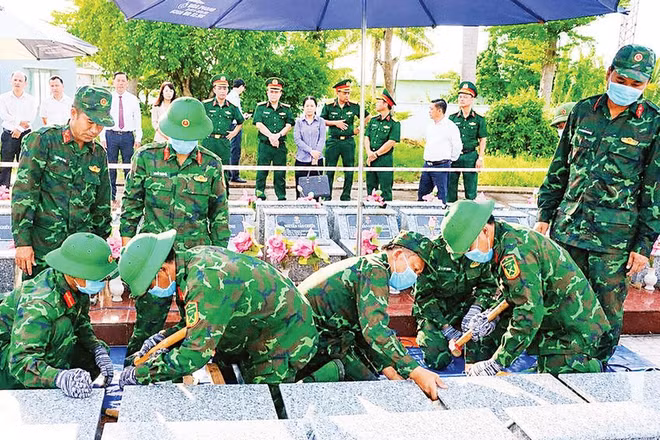 Lực lượng chuyên môn tiến hành lấy mẫu ADN đối với những phần mộ chưa xác định được thông tin tại Nghĩa trang liệt sĩ Châu Thành, xã Phú Hựu, tỉnh Đồng Tháp (Ảnh VIỆT TIẾN)